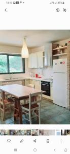 a kitchen with a table and a white refrigerator at Lefkada Eli's amazing beach house in Nikiana
