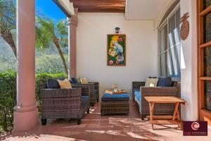 un patio con sillas de mimbre y una mesa de madera. en Casa Esperanza SJDS en San Juan del Sur