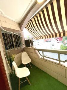 uma varanda com 2 cadeiras e uma janela em Cheb's House em Abidjan