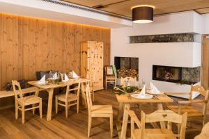 a restaurant with wooden walls and tables and a fireplace at Gasthof Hubertus in Saalfelden am Steinernen Meer