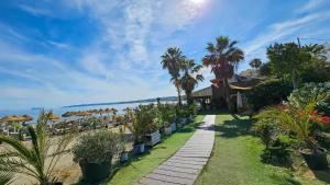 ścieżka prowadząca do ośrodka z palmami i oceanem w obiekcie Dúplex con vistas al mar, playa y puerto a pasos w mieście Estepona