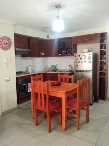 a kitchen with a wooden table and chairs and a refrigerator at Arriendo Departamento a Turistas en Santiago in Santiago