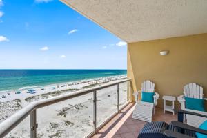 a balcony with chairs and a view of the beach at Emerald Isle Unit 607 in Pensacola Beach