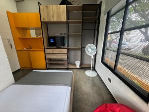 a room with a bed and a window with a fan at Hotel Living Box San Fernando Cali in Cali