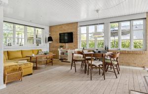 a living room with a table and chairs and a couch at 3 Bedroom Awesome Home In Brenderup Fyn in Skovs-Højrup
