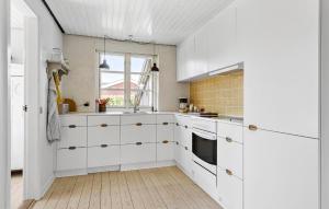 a kitchen with white cabinets and a window at 3 Bedroom Awesome Home In Brenderup Fyn in Skovs-Højrup