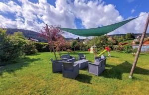 a group of chairs in a yard with a green canopy at 5 Bedroom Nice Home In Xonrupt-Longemer in Xonrupt-Longemer