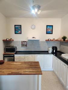 a kitchen with white cabinets and a counter top at SeaView Apartment in Taʼ Ġokondu