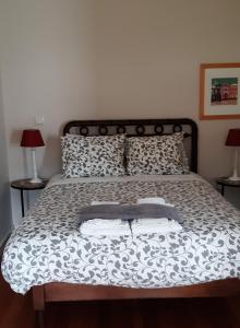uma cama com duas almofadas e duas toalhas em Quinta D'Avó Amélia em Alquerubim
