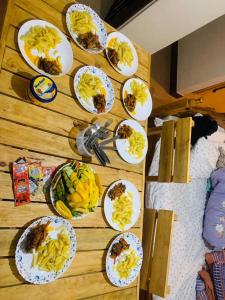 einem Holztisch mit Teller mit Lebensmitteln darauf in der Unterkunft Cactus House Experience in Arusha