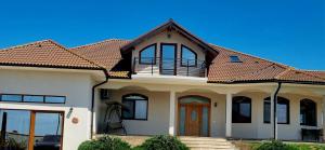 a large white house with a roof at Denisa in Limanu