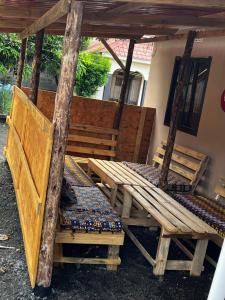 einem Picknicktisch aus Holz und einer Bank unter einer Pergola in der Unterkunft Cactus House Experience in Arusha