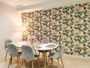 ポロップにあるAmberes apartment, a stylish villa's independent downstairs apartment with private swimming pool and terraceのダイニングルーム(トロピカルな壁紙のテーブルと椅子付)