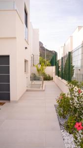 ポロップにあるAmberes apartment, a stylish villa's independent downstairs apartment with private swimming pool and terraceの白い壁と花のある家の中庭