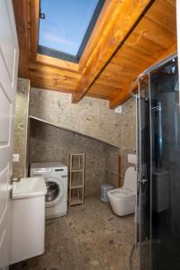 Un baño con lavadora y un inodoro. en Vila Klaro, en Shkodër