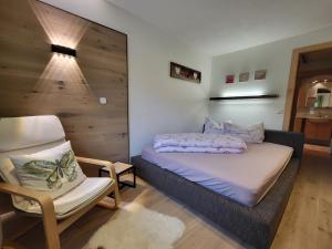 テルフェス・イム・シュトゥーバイにあるFerienwohnungen Unterluimesの小さなベッドルーム(ベッド1台、椅子付)