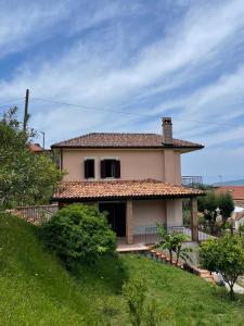 una casa en una colina con un patio de césped en Pink House, en Perdifumo