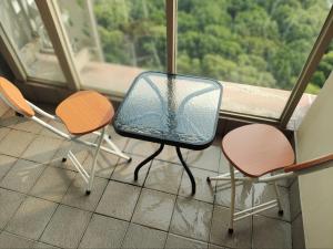 two chairs and a table in a room with a window at Apartment gold coast Pik in Jakarta