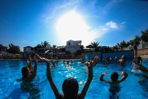 a group of people are in a swimming pool at Villaggio Camping Oasi in Vieste