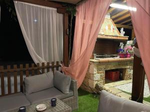 een patio met een bank en een stenen open haard bij Marios guesthouse Pelion in Tsagarada