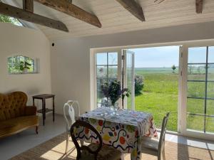a dining room with a table and a view of a field at Ängahuset in Glemminge