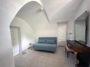 een woonkamer met een blauwe bank en een spiegel bij Villa Luce in Bisceglie