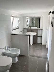 een witte badkamer met een toilet en een wastafel bij Villa Luce in Bisceglie