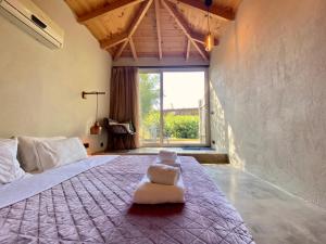a bedroom with a large bed with a white chair on it at Kali Zoi -B&B Zakynthos in Amoudi
