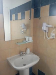 uma casa de banho com um lavatório e um espelho em Toni´s Guesthouse em Kavos