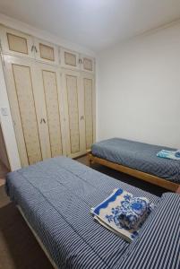 Un dormitorio con dos camas con sábanas azules y blancas. en Plaza 23, en Bahía Blanca