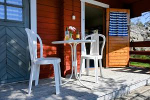 two white chairs and a table on a porch at Strandhugget BnB in Sottunga