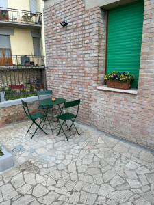 un patio con mesa y sillas junto a un edificio de ladrillo en La Casina di Cinzia en San Gimignano