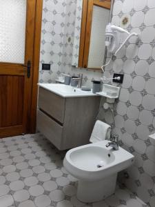 y baño con aseo, lavabo y espejo. en Camera Relax confortevole e riservata in villa, en Massa Lubrense