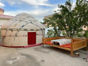 une grande tente en forme de dôme avec un lit en face de celle-ci dans l'établissement NUKUS GUEST HOUSE, à Noukous