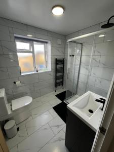 a white bathroom with a sink and a shower at Newly built one bedroom flat in Kidlington, Oxfordshire in Kidlington