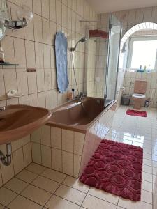 ein Badezimmer mit einer Badewanne und einem Waschbecken in der Unterkunft HandwerkerZimmer in Düsseldorf