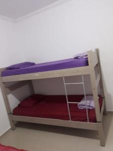 a bunk bed in a room with purple and purple sheets at Pesqueiro Restaurante e Pousada Pingo de Ouro in Piedade
