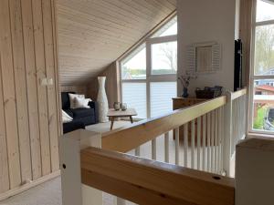 Zimmer mit einer Treppe, einem Sofa und einem Fenster in der Unterkunft Holiday home Seeidyll am D mmer See D mmer in Dümmer