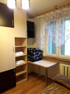 Un pequeño escritorio en una habitación con ventana en Apartament *Jasmine* en Dąbrowa Górnicza