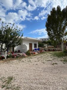 a small white house with a gravel driveway at Dea Apartament in Ksamil