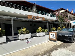 a car parked in front of a building with plants at K.G apartment in Pefkohori