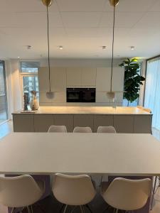una cucina con un grande tavolo bianco e sedie di Platinum VIP - Aurora luxury house a Tromsø