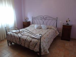 una camera da letto con un letto con copriletto floreale di Agriturismo Camera Rosa a Todi