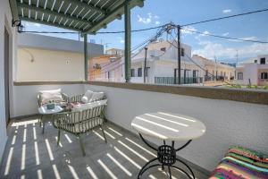 a patio with two chairs and a table on a balcony at Casa Dell Artista with private jacuzzi in Kos