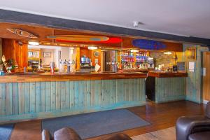 a bar in a pub with a counter and chairs at The Clachan Hotel, Lochearnhead in Lochearnhead