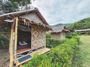 a small hut with a bed in a field at Samui Camping Farm in Laem Sor