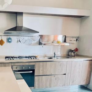 a kitchen with a sink and a stove at Antonia's Home - casa per le vacanze con giardino e veranda attrezzati in San Domino