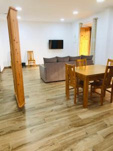 ein Wohnzimmer mit einem Tisch und einem Sofa in der Unterkunft AMU- Apartamentos Mistérios da Urzelina in Urzelina