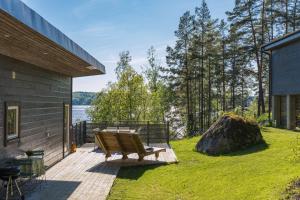 una terraza de madera con un banco en el lateral de una casa en Lundby, en Finspång