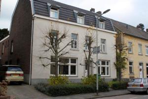 a white house with cars parked in front of it at B&B Gerlachus in Valkenburg